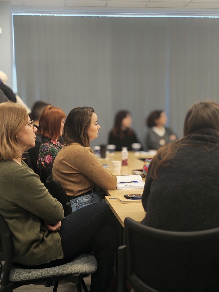 na zdjęciu grupa osób podczas szkolenia siedząca za stołami