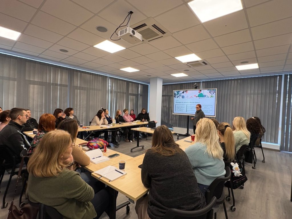 na zdjęciu grupa osób podczas szkolenia siedząca za stołami